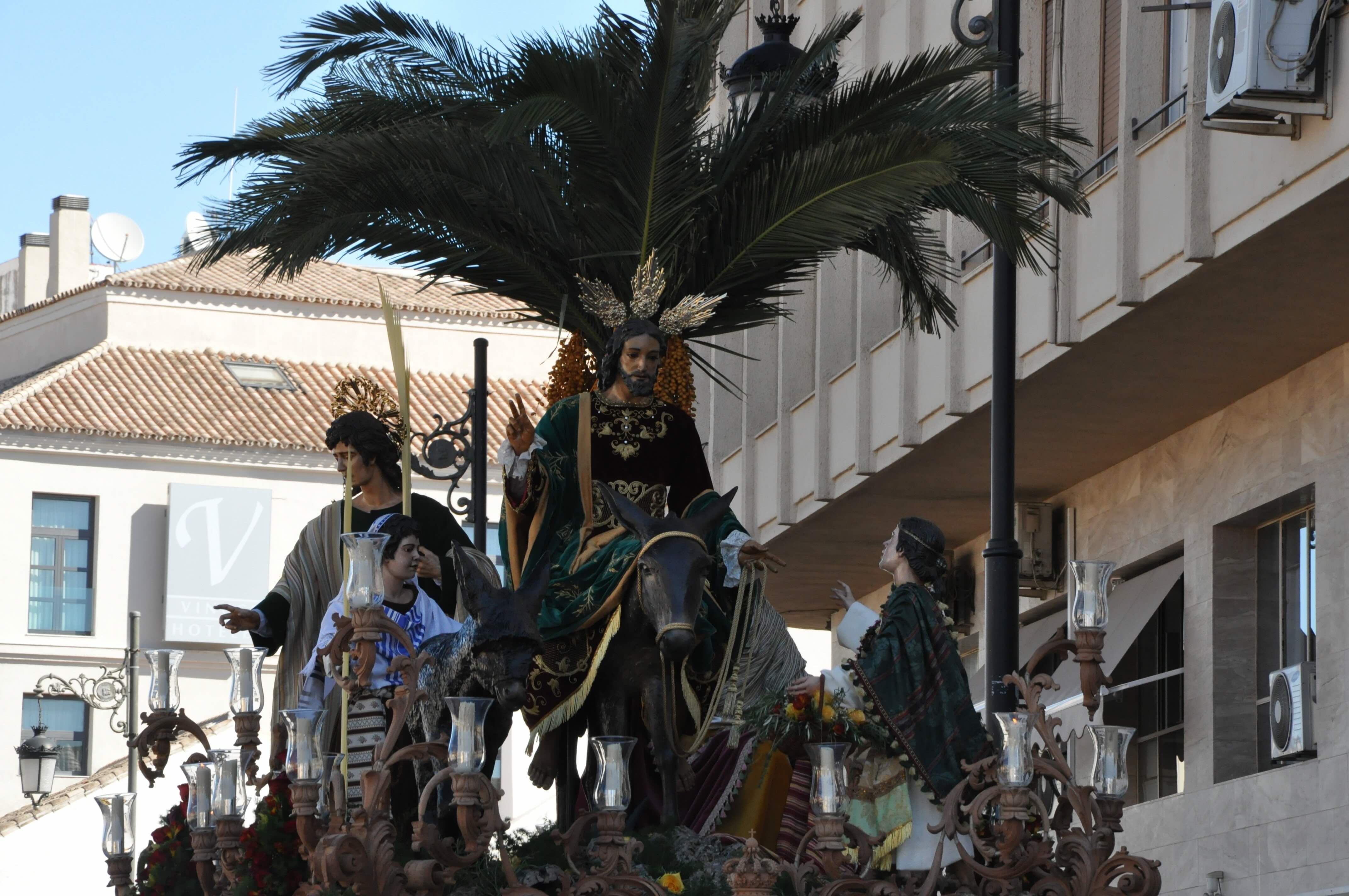 Candlelit Semana Santa procession moving through a narrow street in Seville at night